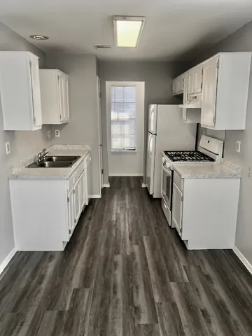 a kitchen with a stove a sink dishwasher and a refrigerator