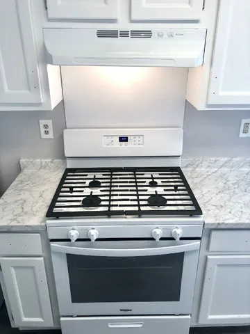 a stove top oven sitting inside of a kitchen