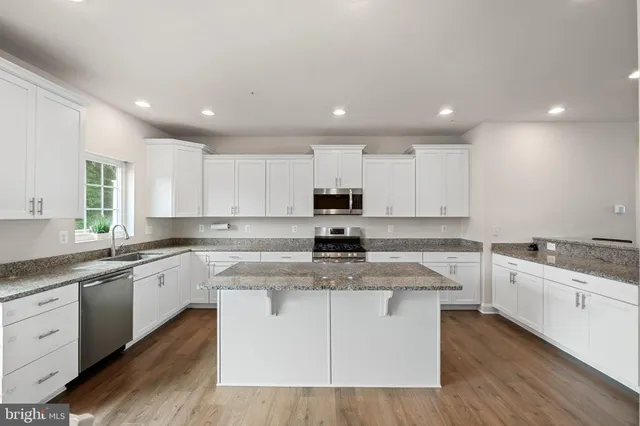 a kitchen with white cabinets appliances and sink