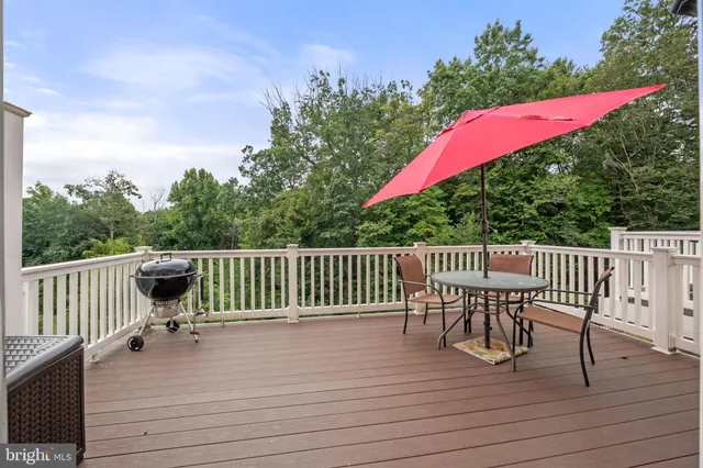 a view of a deck with a table and chairs with wooden floor and fence