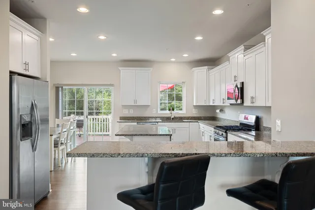 a kitchen with stainless steel appliances granite countertop a refrigerator and a sink