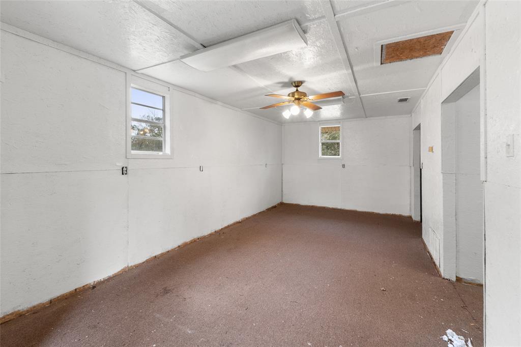 1621 Baseball Loop Diana, TX 75640 - Photo 28 of 38 an empty room with a ceiling fan and a window