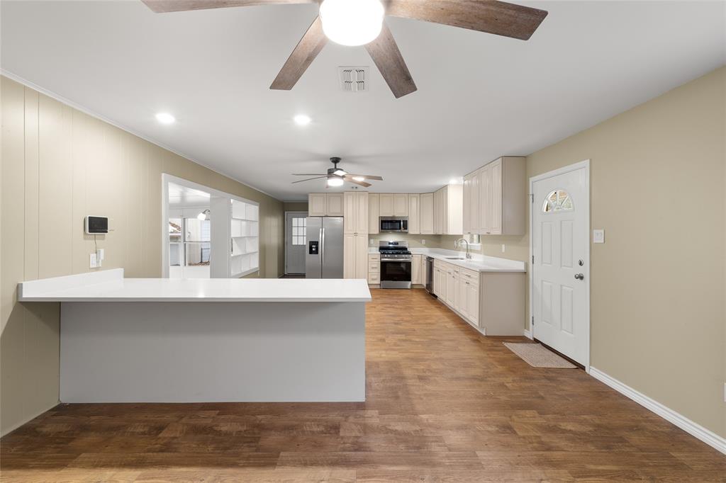 1621 Baseball Loop Diana, TX 75640 - Photo 5 of 38 a large white kitchen with kitchen island a sink stainless steel appliances and cabinets