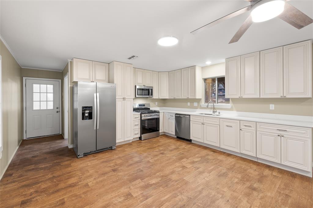 1621 Baseball Loop Diana, TX 75640 - Photo 6 of 38 a kitchen with white cabinets stainless steel appliances and window