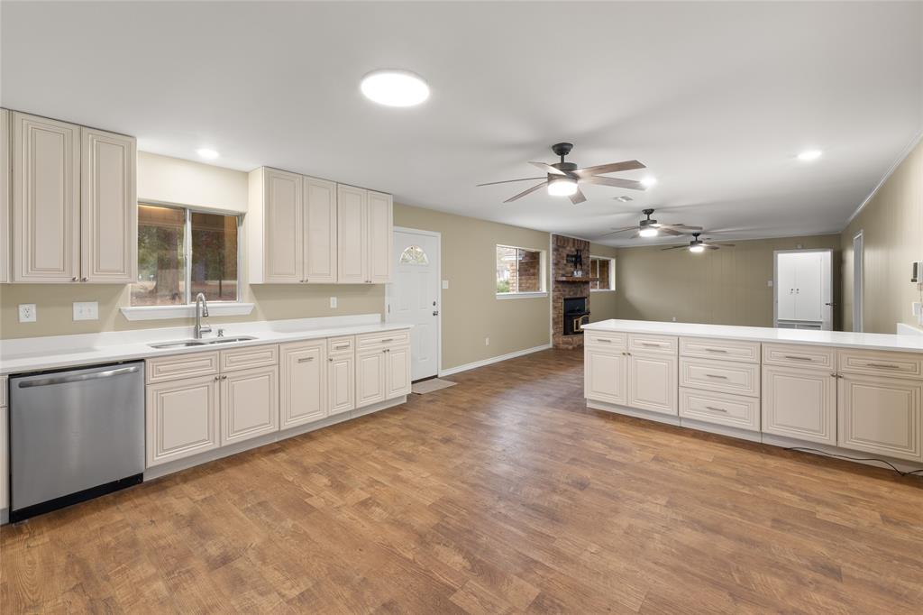 1621 Baseball Loop Diana, TX 75640 - Photo 9 of 38 a large white kitchen with a sink dishwasher a stove and a refrigerator with wooden floor