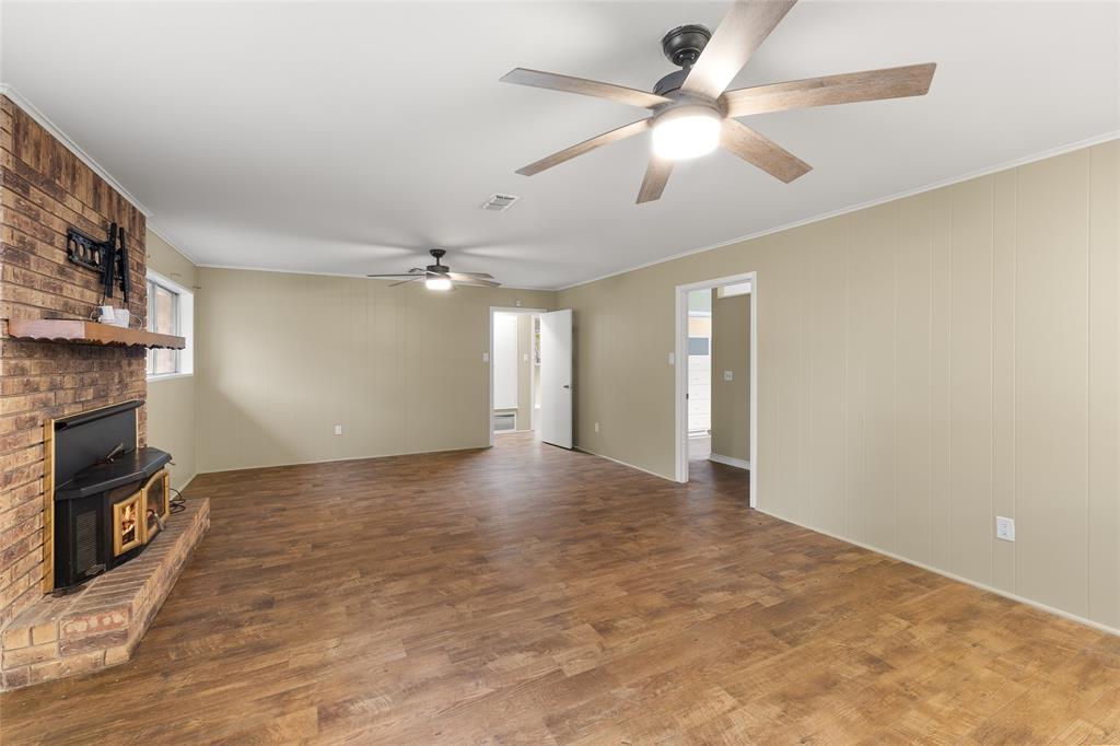 1621 Baseball Loop Diana, TX 75640 - Photo 10 of 38 wooden floor in an empty room with a fireplace