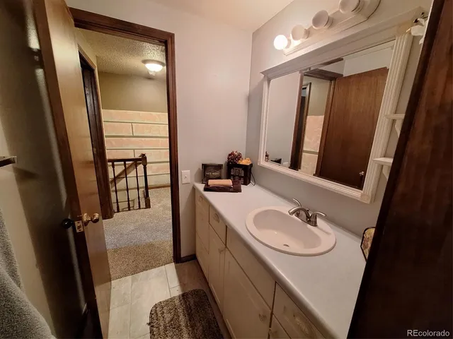 a bathroom with a sink vanity granite and a mirror