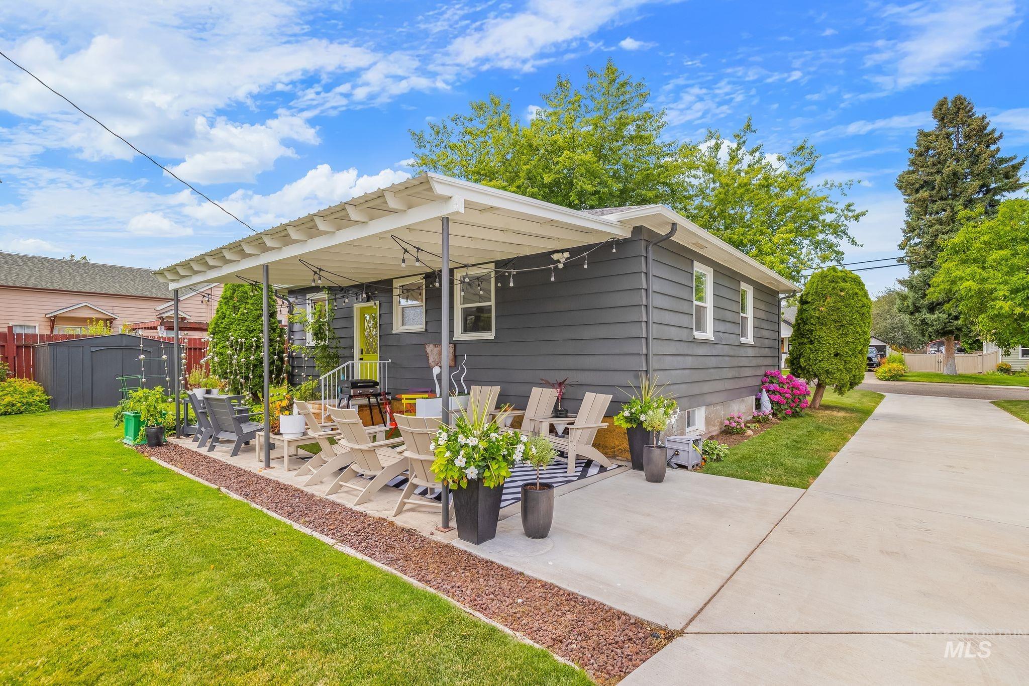 1315 8th Street Clarkston, WA 99403 - Photo 32 of 37 Exterior featuring dark gray siding, a covered patio, and a bright yellow entry door