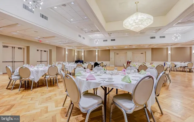 a view of a hallway with dining area and chandelier