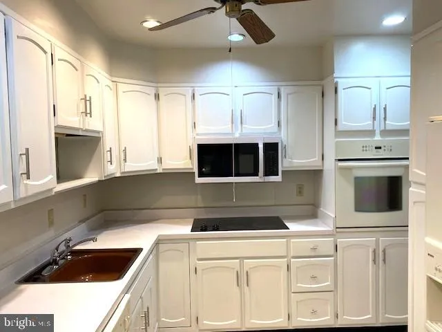 a kitchen with white cabinets and sink