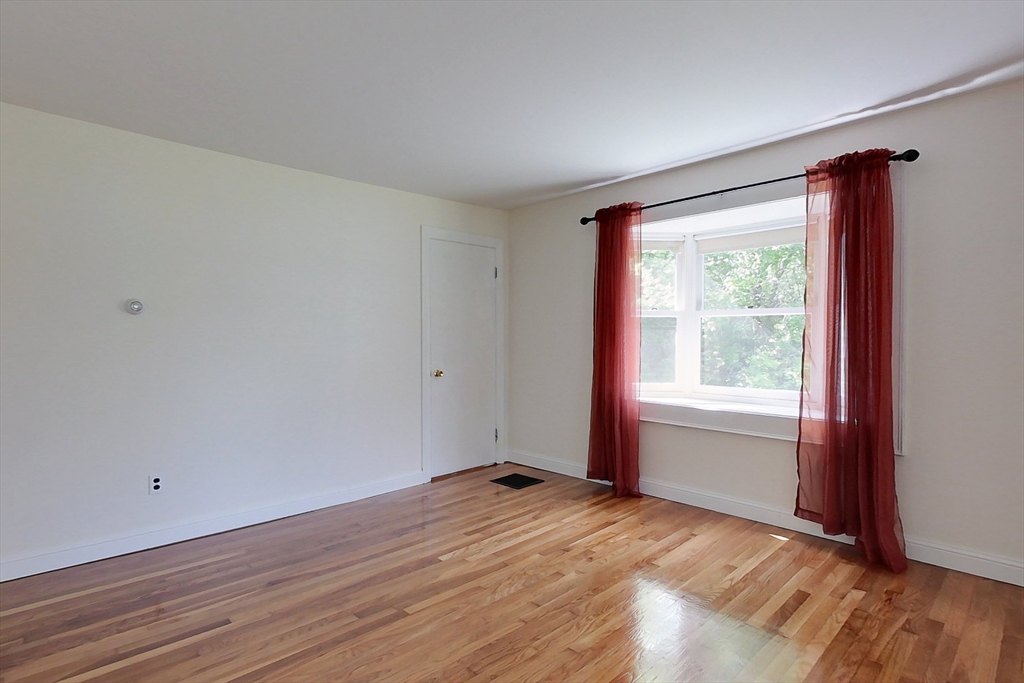 92 Squannacook Road Shirley, MA 01464 - Photo 9 of 38 a view of an empty room with wooden floor and a window