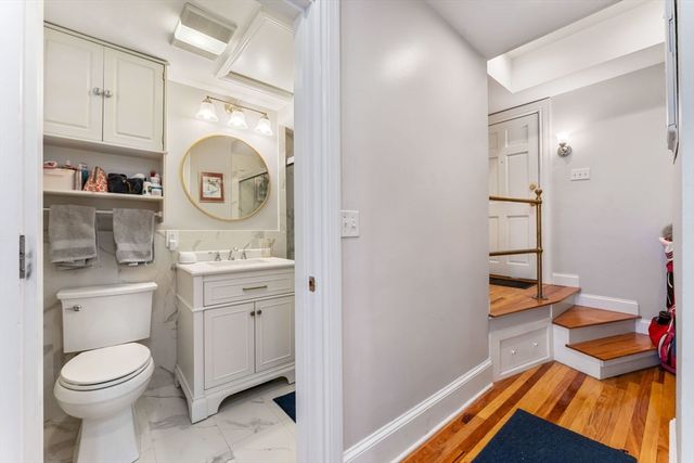 a bathroom with a toilet sink vanity and mirror