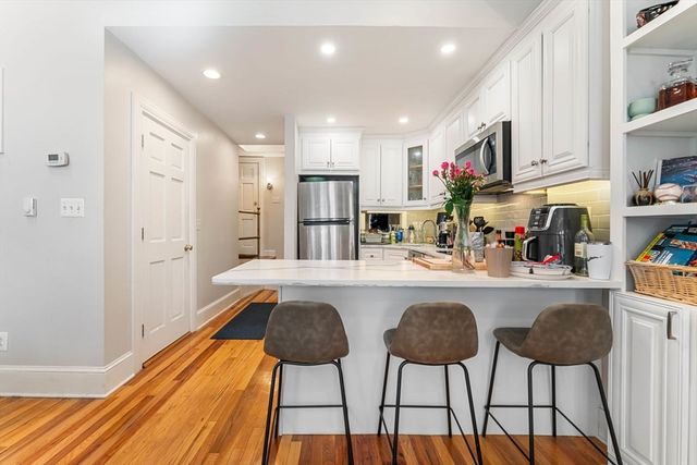 a kitchen with stainless steel appliances granite countertop a refrigerator and a stove top oven