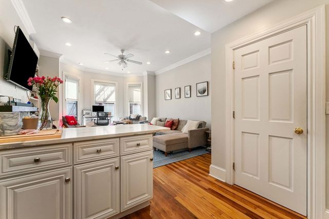 a living room with furniture a flat screen tv and a potted plant