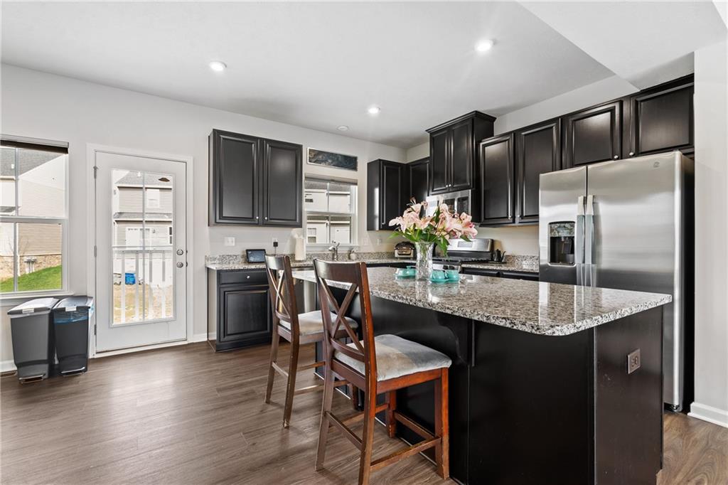 327 Helenium Drive Mars, PA 16046 - Photo 9 of 35 a kitchen with stainless steel appliances granite countertop a refrigerator a stove a sink a dining table and chairs