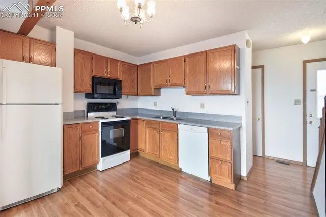a kitchen with stainless steel appliances a refrigerator stove top oven and sink