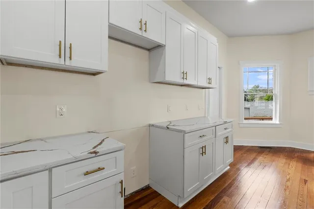 a kitchen with granite countertop white cabinets and white appliances