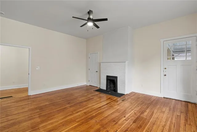 a view of empty room with wooden floor and fireplace