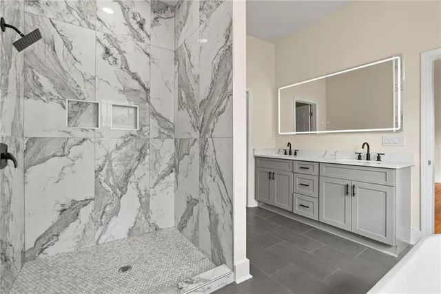 a spacious bathroom with double vanity and a mirror