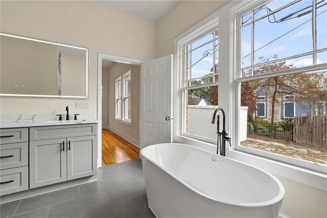 a spacious bathroom with a tub sink and mirror
