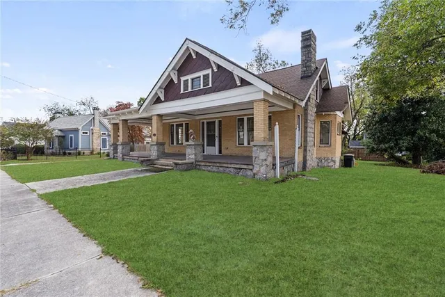 a front view of a house with a garden and trees