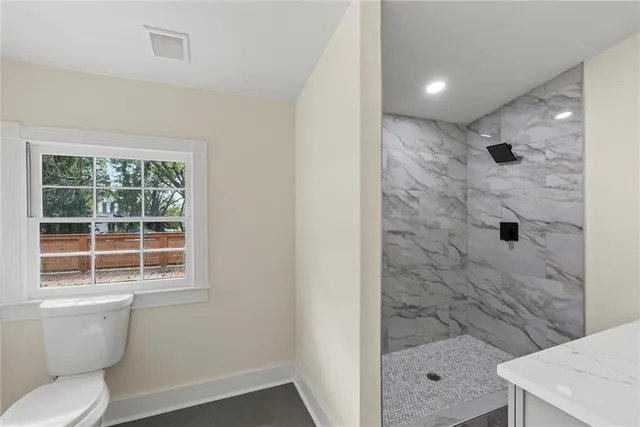 a bathroom with a toilet and a shower