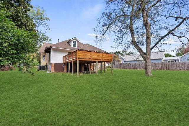 a view of a house with a big yard and large trees