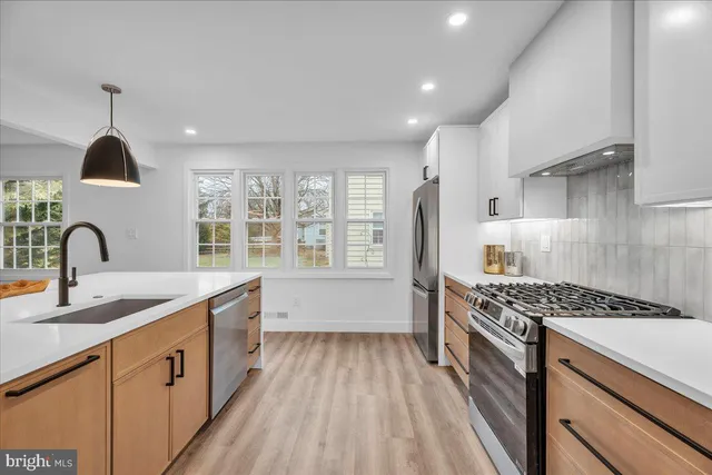 a kitchen with stainless steel appliances granite countertop a sink stove and cabinets