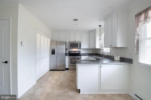 a kitchen with stainless steel appliances granite countertop a stove a sink and a refrigerator