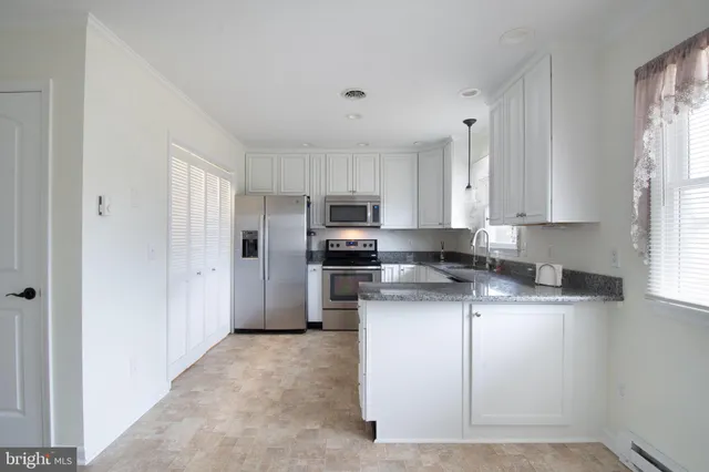 a kitchen with granite countertop a sink dishwasher and a granite counter top