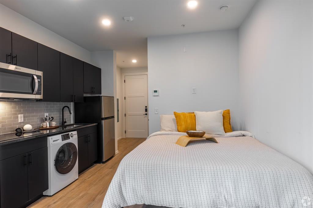 596 West 9th Street, Unit 325 Dallas, TX 75208 - Photo 22 of 25 a bedroom with a bed a mirror and closet