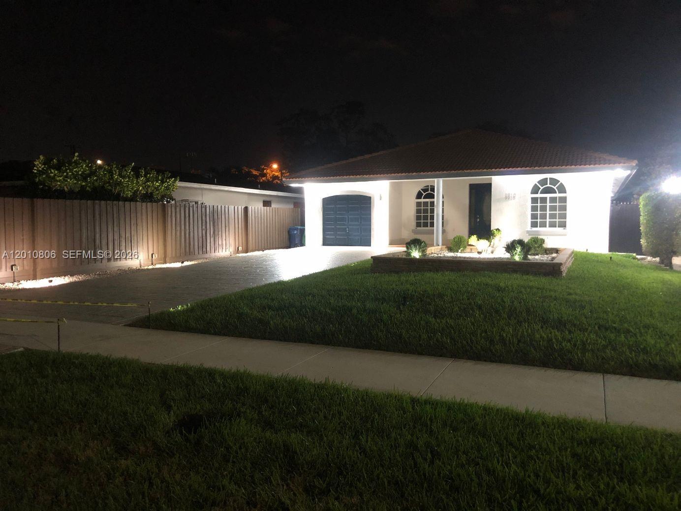 9910 Southwest 23rd Street Miami, FL 33165 - Photo 3 of 39 a front view of a house with a garden and yard
