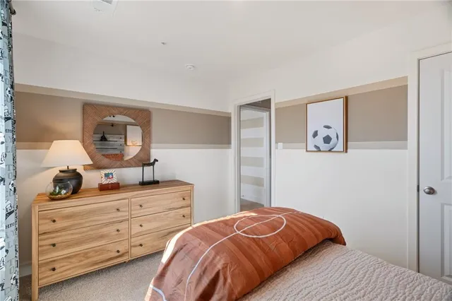 a bedroom with a bed and a dresser in it