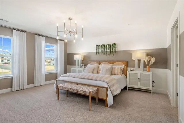 a spacious bedroom with a bed and a chandelier