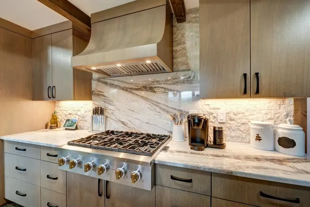 a kitchen with stainless steel appliances kitchen island granite countertop a stove and a sink