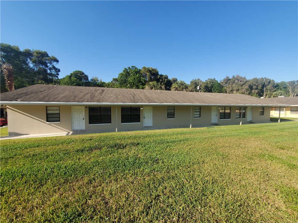 a front view of house with yard and trees in the background