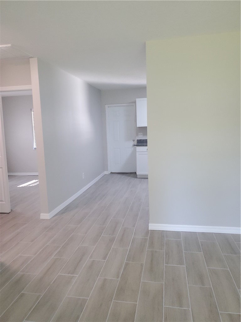 3300 South 7th Street, Unit B Fort Pierce, FL 34982 - Photo 11 of 32 a view of empty room with wooden floor
