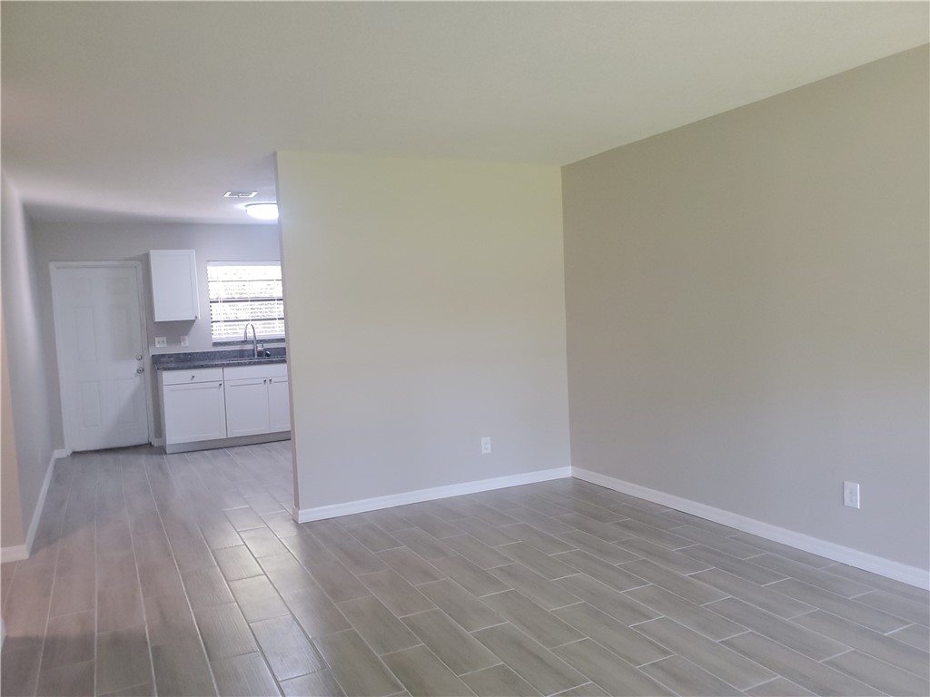 3300 South 7th Street, Unit B Fort Pierce, FL 34982 - Photo 13 of 32 wooden floor in an empty room