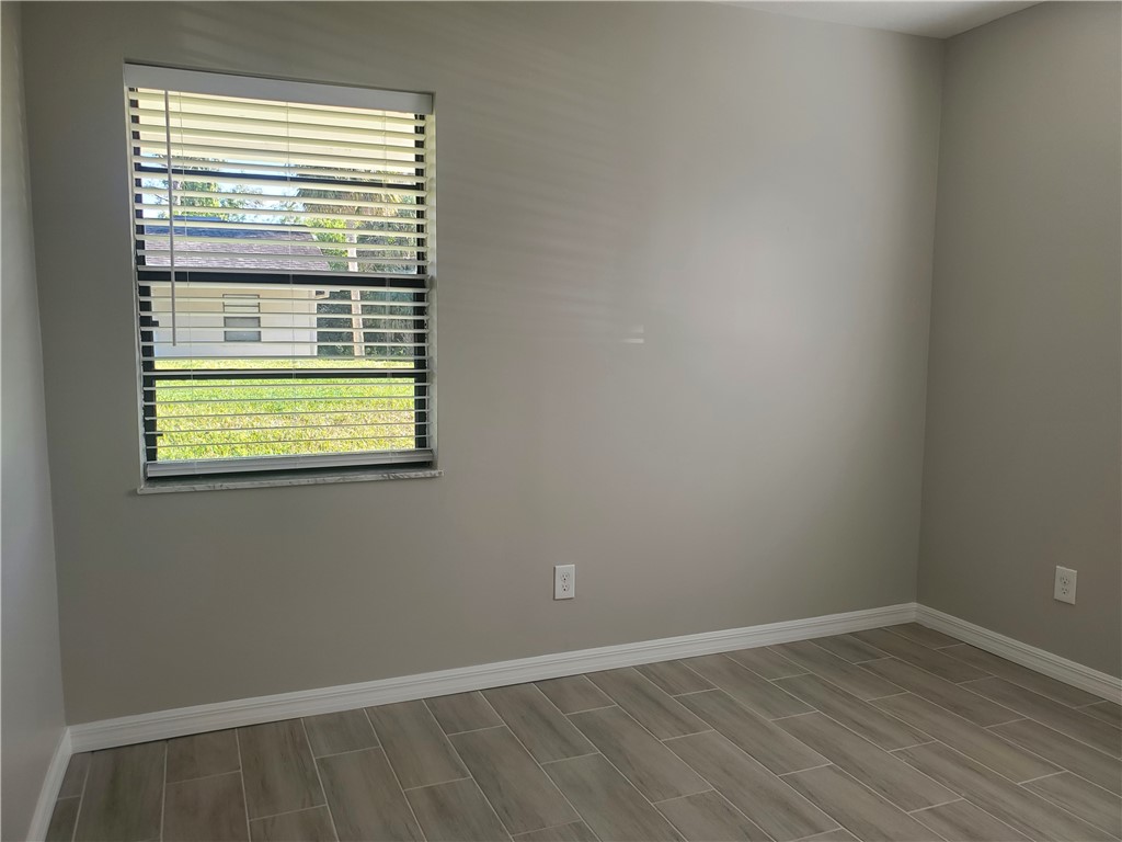 3300 South 7th Street, Unit B Fort Pierce, FL 34982 - Photo 23 of 32 a view of an empty room with wooden floor and a window