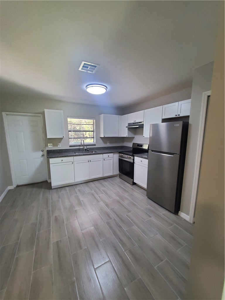 3300 South 7th Street, Unit B Fort Pierce, FL 34982 - Photo 3 of 32 a kitchen with granite countertop a refrigerator and a stove
