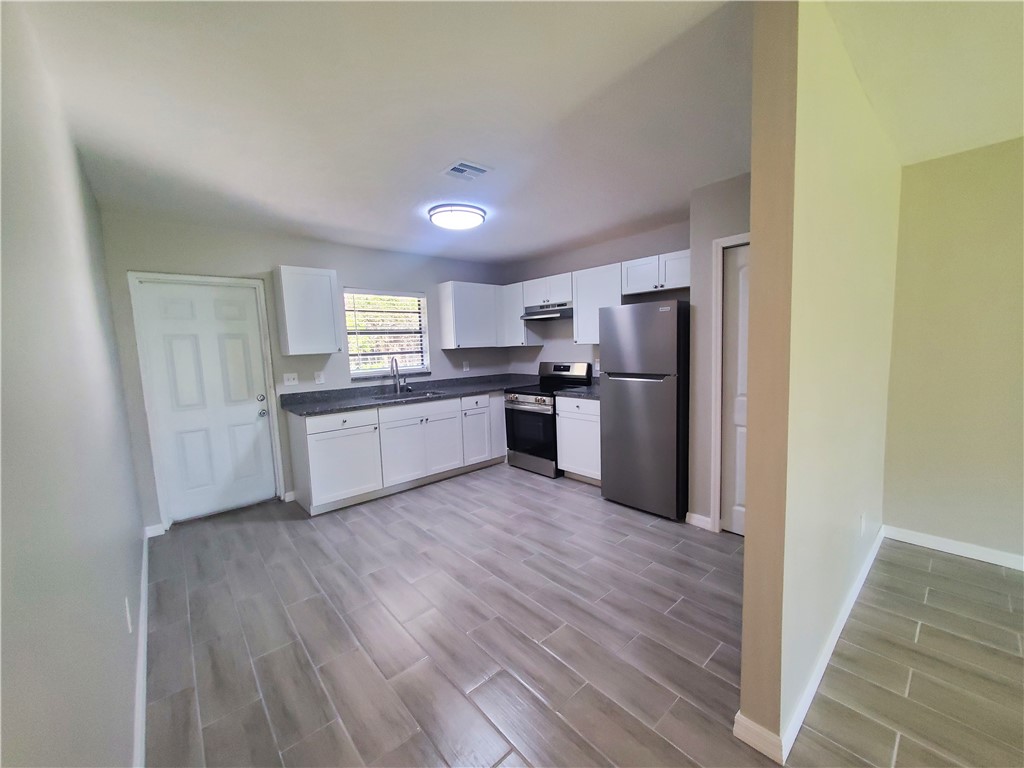 3300 South 7th Street, Unit B Fort Pierce, FL 34982 - Photo 4 of 32 a kitchen with a refrigerator and a stove top oven