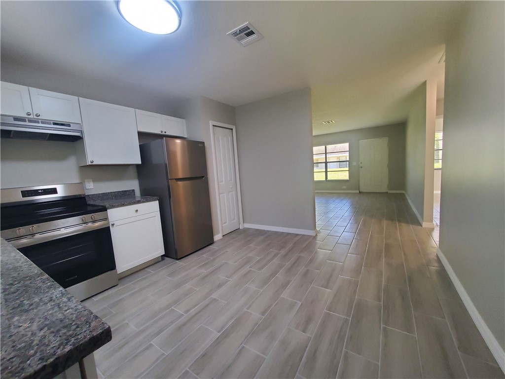 3300 South 7th Street, Unit B Fort Pierce, FL 34982 - Photo 7 of 32 a kitchen with a refrigerator and a stove top oven
