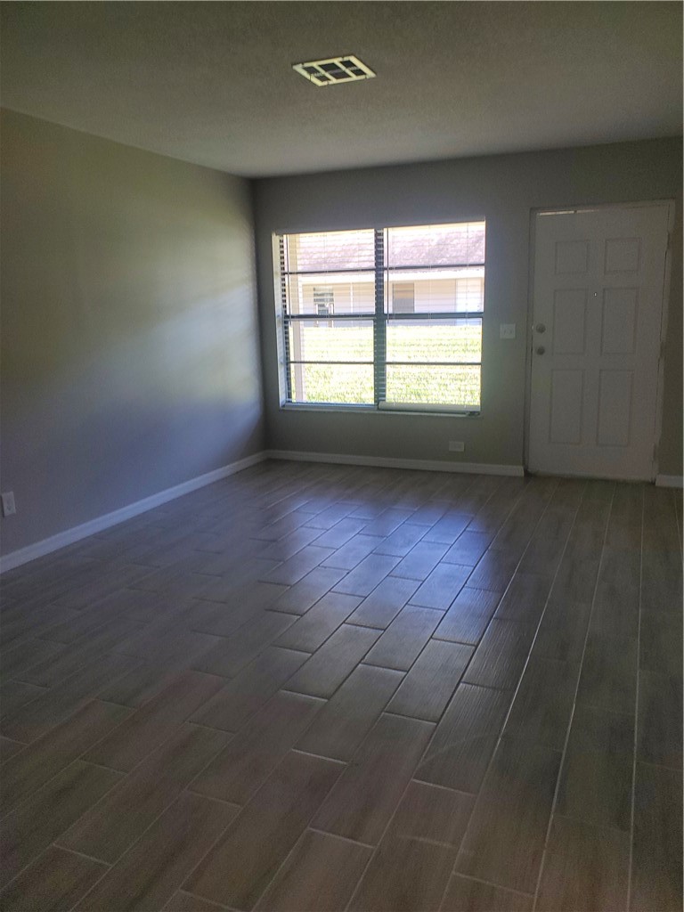 3300 South 7th Street, Unit B Fort Pierce, FL 34982 - Photo 10 of 32 wooden floor in an empty room with a window