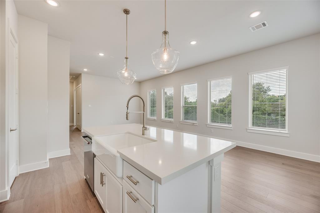 920 Ash Road Plano, TX 75075 - Photo 11 of 27 a large kitchen with kitchen island a large window a sink and appliances