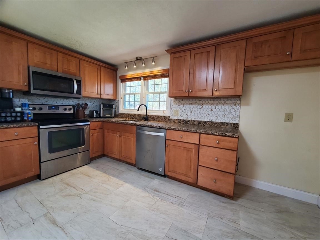 27 Upton Street Brockton, MA 02302 - Photo 5 of 24 a kitchen with stainless steel appliances granite countertop a stove sink microwave and window