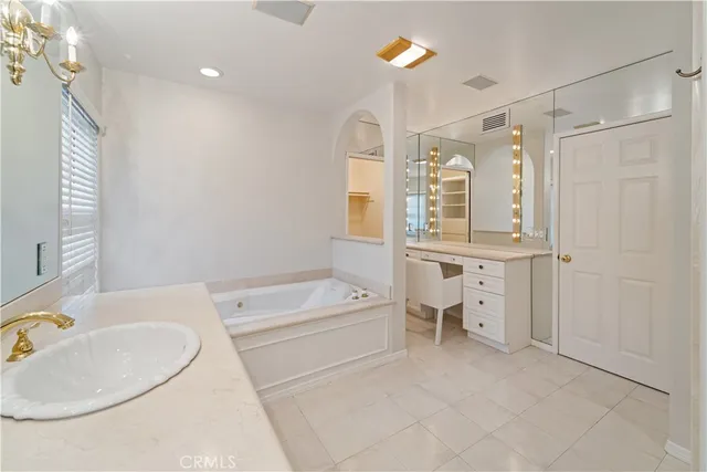 a bathroom with a tub a sink and mirrors