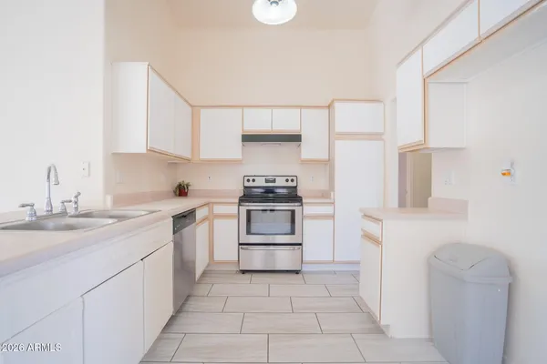 a kitchen with a stove sink and cabinets