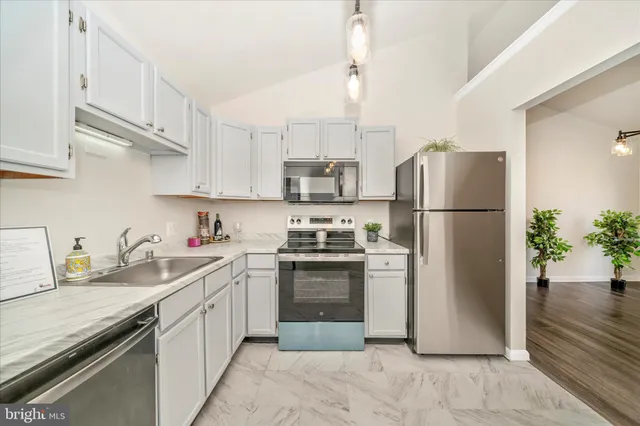 a kitchen with stainless steel appliances granite countertop a refrigerator sink and stove
