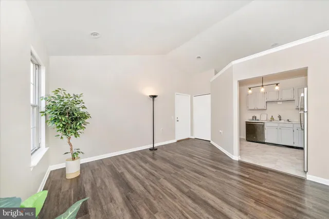 a view of a room with wooden floor and a potted plant