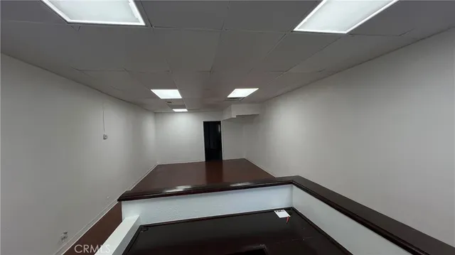 a view of an empty room with wooden floor and a floor to ceiling window